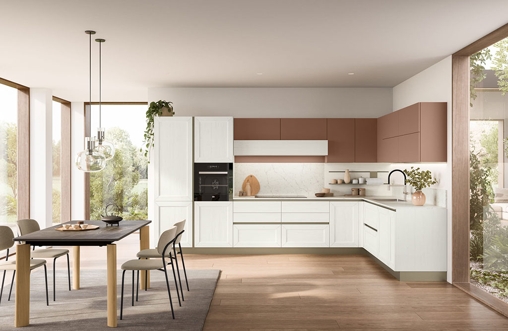 Cucina Tablet Veneta Cucine vista laterale con colonna forno, composizione ad angolo bianca e pensili terracotta, illuminazione sottopensile