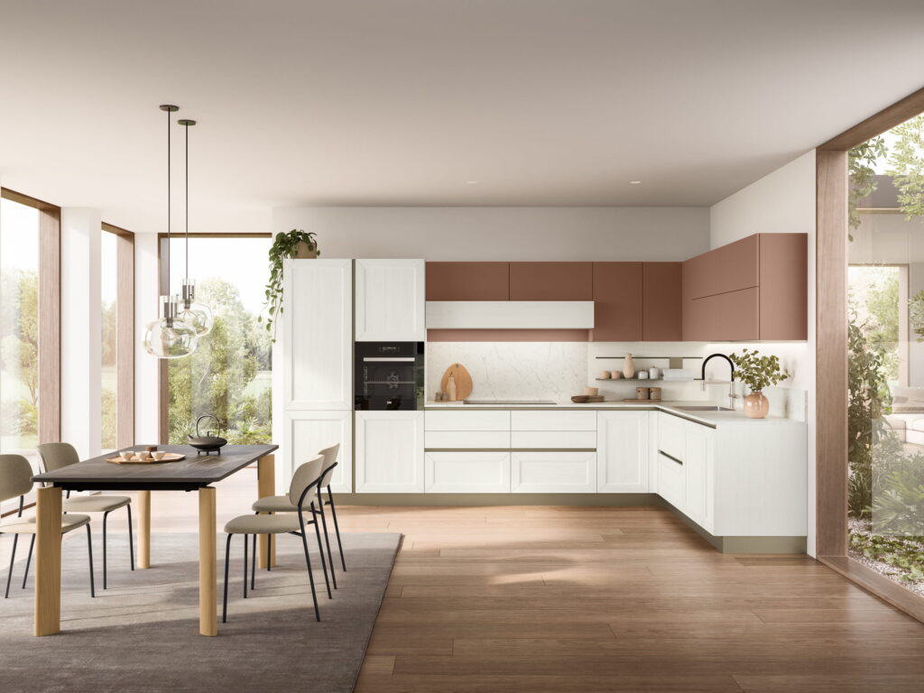 Cucina Tablet Veneta Cucine in ambiente open space con basi bianche a telaio, pensili terracotta e zona pranzo integrata